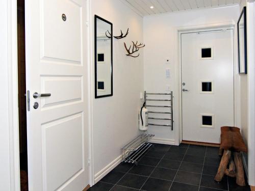 a hallway with a white door and a black tile floor at Ottsjö Bear Lodge in Ottsjö