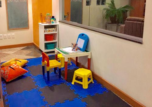 a room with a table and two chairs and a desk at Hotel Metropolitan Canoas in Canoas