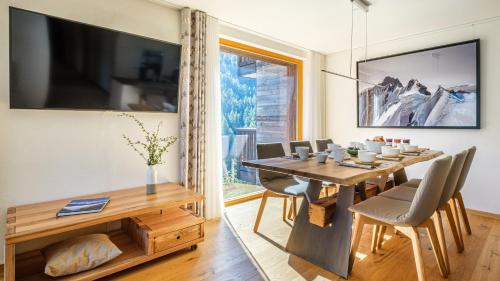 a dining room with a table and chairs and a large window at Chalet Les Rahâs by Mrs Miggins in Grimentz