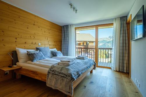 a bedroom with a large bed and a large window at Chalet Les Rahâs by Mrs Miggins in Grimentz