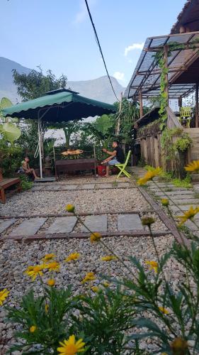 a person sitting on a bench under an umbrella at Tavan View Homestay in Sa Pa
