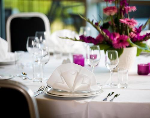 a table with a white table cloth and a plate with a napkin at Hotell Charlottenberg in Charlottenberg