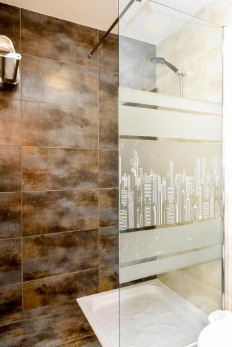 a shower with a glass wall with a city mural at Apartamento El Fangar in Deltebre
