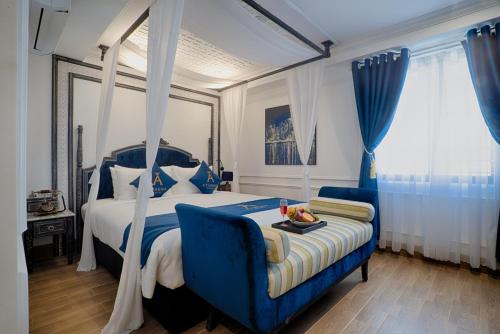 a bedroom with a blue bed and a blue chair at Athena Hotel Quy Nhơn in Quy Nhon