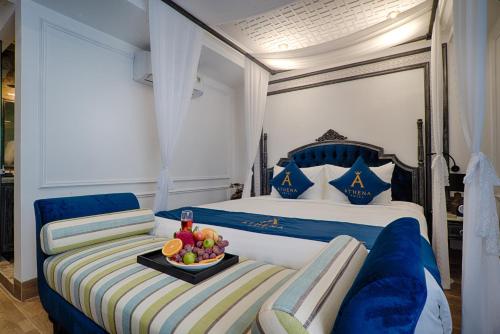 a hotel room with a bed with a tray of fruit at Athena Hotel Quy Nhơn in Quy Nhon