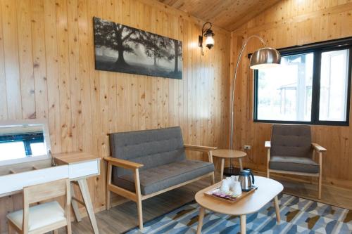 2 sillas y una mesa en una habitación con paredes de madera en 河岸香榭&田苑民宿, en Dongshan