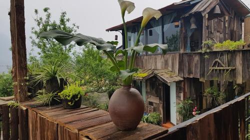 a vase with flowers in it sitting on a fence at Tavan View Homestay in Sa Pa