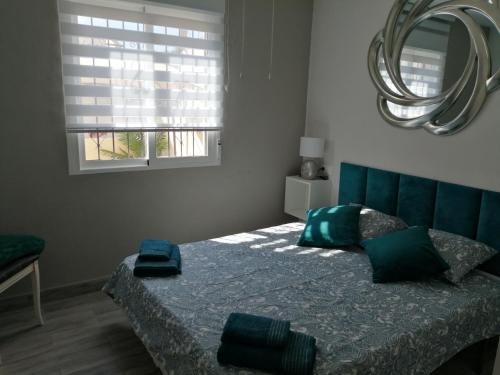 トレビエハにあるCasas Holiday - Los Balcones 2のベッドルーム1室(緑のヘッドボードと鏡付きのベッド1台付)