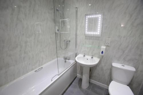 a bathroom with a toilet and a sink and a shower at The Merchant City Inn in Glasgow