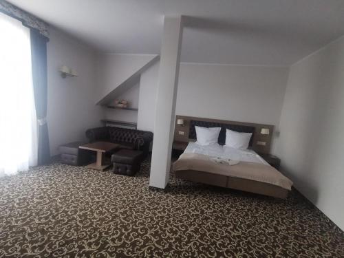 a bedroom with a bed and a couch in it at Hotel Grodzisko in Grodzisk Mazowiecki