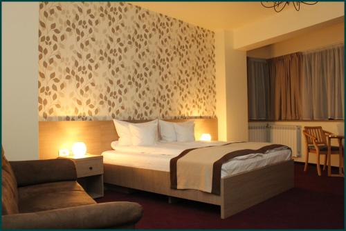 a hotel room with a bed and a chair at Pensiunea Rix Rooms in Focşani