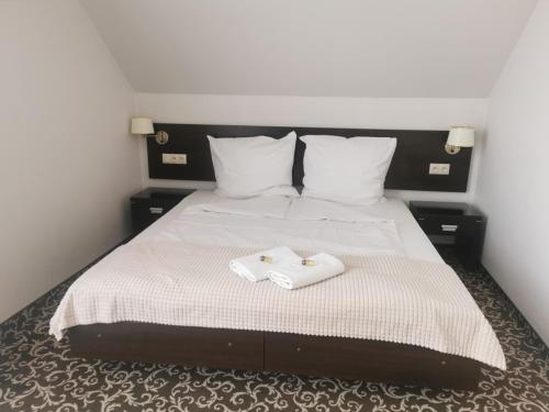 a bedroom with a bed with two towels on it at Hotel Grodzisko in Grodzisk Mazowiecki