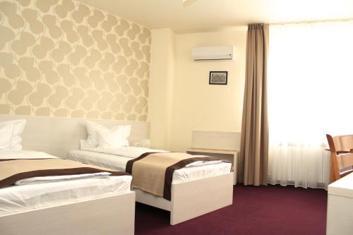 a hotel room with two beds and a window at Pensiunea Rix Rooms in Focşani