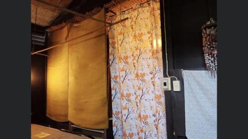 a curtain with flowers on it in a room at Pano Solar Guest House (พาโน โซล่า เกสเฮ้าส์ ) in Trat