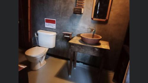 a bathroom with a toilet and a sink at Pano Solar Guest House (พาโน โซล่า เกสเฮ้าส์ ) in Trat