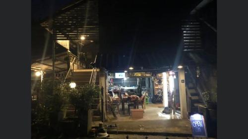 a restaurant at night with a table and chairs at Pano Solar Guest House (พาโน โซล่า เกสเฮ้าส์ ) in Trat