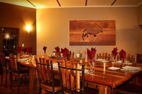 a dining room with a long table with red napkins at Africa Awaits Lodge & Safaris in Gobabis