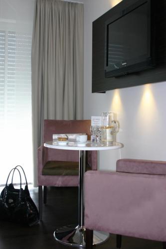 a room with a table and chairs and a tv at Hotel zur Promenade in Donauwörth