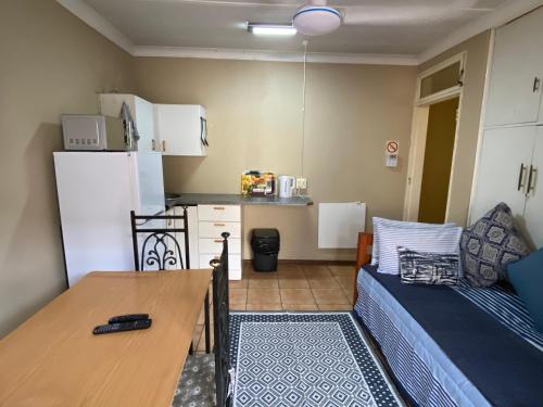 a small kitchen with a couch and a table in a room at Tula@159 in Bloemfontein