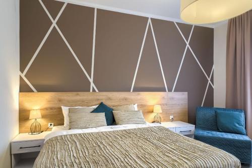 a bedroom with a bed and a blue chair at Park Hotel Bydgoszcz in Bydgoszcz