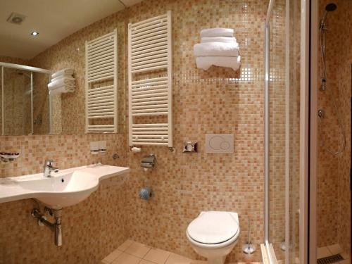 W łazience znajduje się toaleta, umywalka i prysznic. w obiekcie Hotel VZ Měřín w mieście Merin