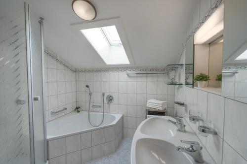 Baño blanco con bañera y lavamanos en Oberstdorfer Bergwelt 320, en Oberstdorf