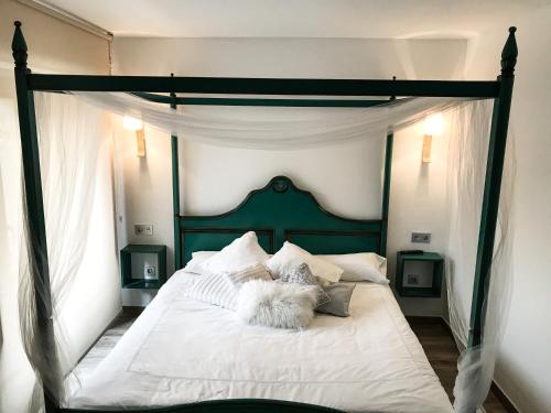 a bedroom with a white bed with a green canopy at La Casona de Alútiz & Bodega in Samaniego