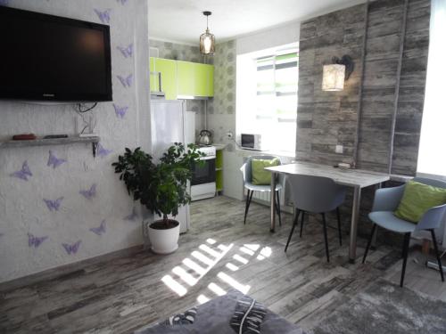 a kitchen and dining room with a table and chairs at Apartment WAVE,в центре! in Khmelʼnytsʼkyy
