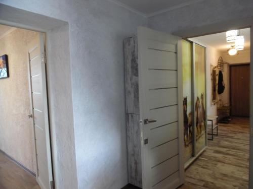a hallway with a white door and a room at Apartment WAVE,в центре! in Khmelʼnytsʼkyy