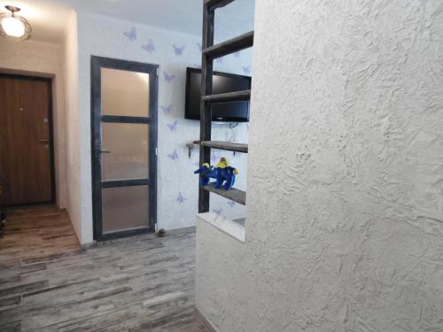 a room with a wall with a shelf and a window at Apartment WAVE,в центре! in Khmelʼnytsʼkyy