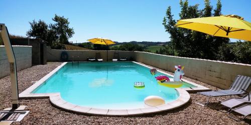 - une petite piscine avec un parasol jaune et une chaise dans l'établissement La Tranquillité, Le Repos, à Nanteuil-Auriac-de-Bourzac