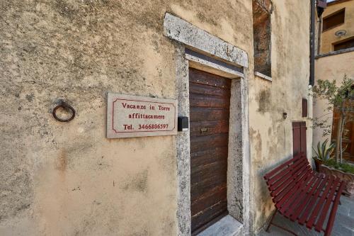 um sinal na lateral de um edifício com uma porta em Vacanze In Torre em Rapolano Terme