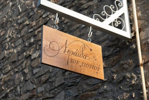 a wooden sign hanging on a wall at Dandy Villas Nymfaio - Snow Fairy - Sauna in Nimfaíon