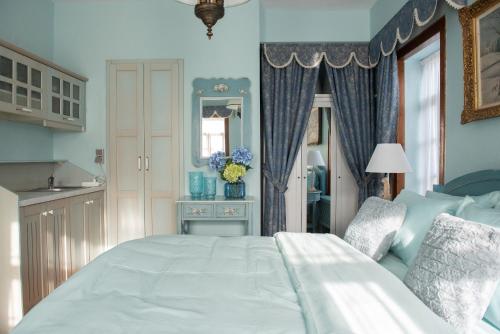 a bedroom with a large white bed and a mirror at Dandy Villas Nymfaio - Snow Fairy - Sauna in Nimfaíon