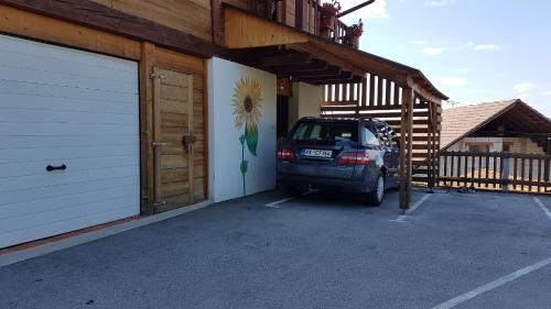 a car parked in a parking lot next to a garage at Gnezdo Vid-ik in Čatež ob Savi