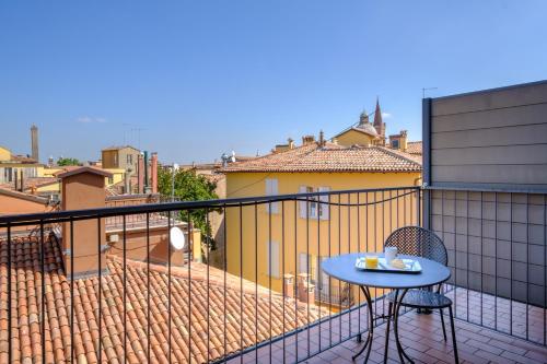 a balcony with a table and chairs on a roof at Hotel Touring in Bologna