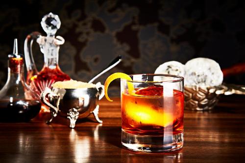 a drink in a glass with a lemon on a table at Kimpton Gray Hotel Chicago by IHG in Chicago