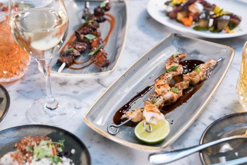 a table with plates of food and a glass of wine at Kimpton Gray Hotel Chicago by IHG in Chicago