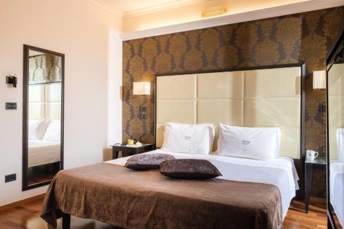 a bedroom with a large bed with a large headboard at Hotel Touring in Bologna