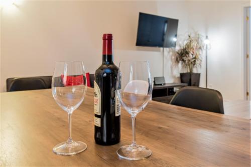 a bottle of wine sitting on a table with two wine glasses at Le Théâtral - En plein coeur de l'action avec stationnement in Quebec City