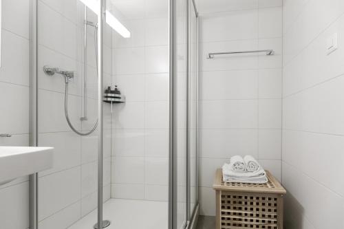 baño blanco con ducha y lavamanos en AirHosted - Lucerne City Centre, en Lucerna