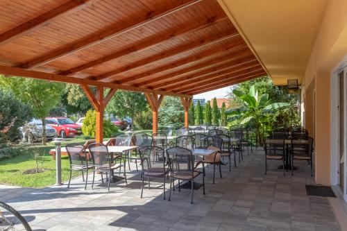 a row of tables and chairs on a patio at Hotel Vital in Zalakaros