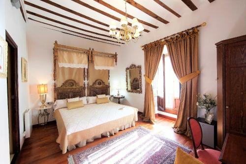 Schlafzimmer mit einem Bett und einem Kronleuchter in der Unterkunft Hotel Boutique Nueve Leyendas in Úbeda