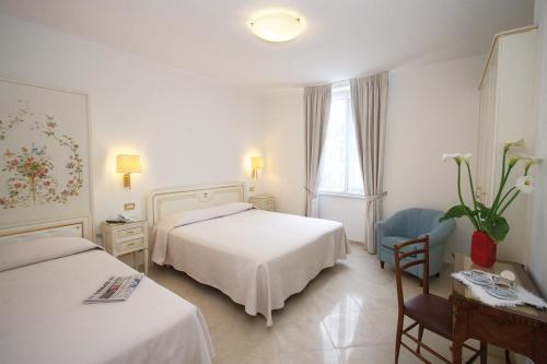 een hotelkamer met twee bedden en een stoel bij Genovese Villa Elena Residence in Varazze