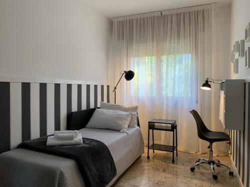 a bedroom with a bed and a chair and a window at Holidays Apartment Toti to fulfill your wishes in Mestre