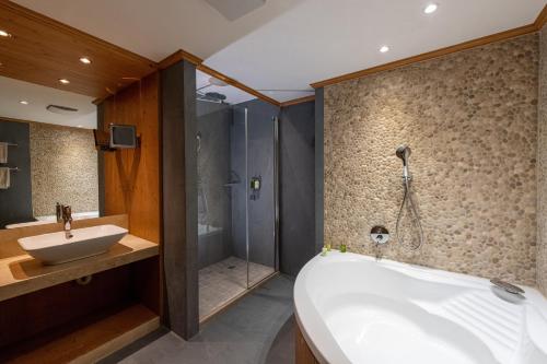 
a bathroom with a shower, sink, and tub at Chalet RoyAlp Hôtel & Spa in Villars-sur-Ollon

