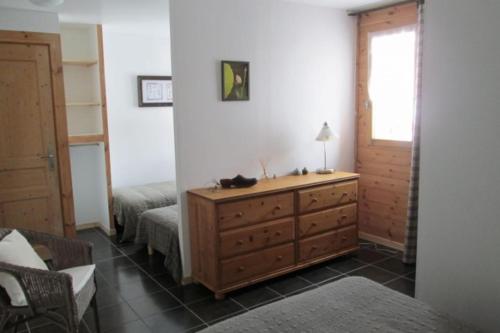 a bedroom with a dresser and a bed and a window at Les Thures Hameau du Roubion Hautes Alpes in Névache