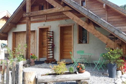 a wooden house with a ladder and some plants at Les Thures Hameau du Roubion Hautes Alpes in Névache