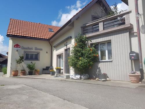 a white building with plants on the side of a street at BnB Comfort Guesthouse Olten - Lostorf in Lostorf