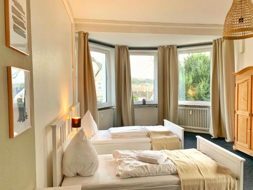 a hotel room with two beds and two windows at Ferienwohnung Stadtvilla in Bad Marienberg